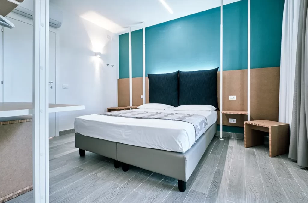 Camera deluxe con letto matrimoniale, design minimal e colori rilassanti.